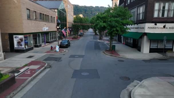 小さな町アメリカ ジョンズタウンPaのメインストリートにアメリカ国旗ペンシルベニア ハイランド コミュニティカレッジと小規模事業所 — ストック動画