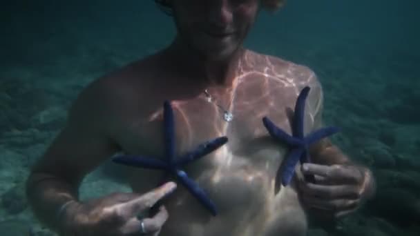 Man Having Fun Plays Two Blue Sea Stars Underwater Linckia — Stock Video