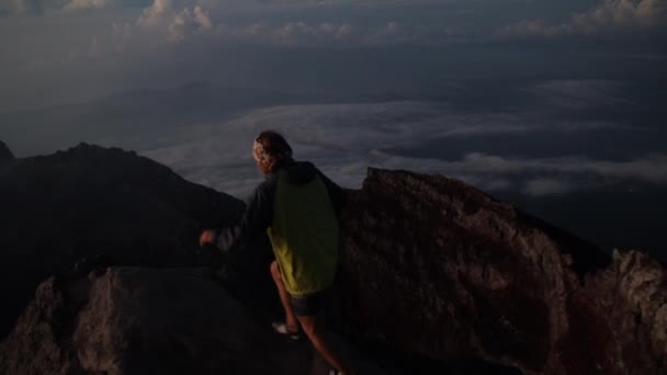 年轻人走在活火山阿贡火山的火山口边缘上 张开双手欣赏日出美景 巴厘印度尼西亚 — 图库视频影像