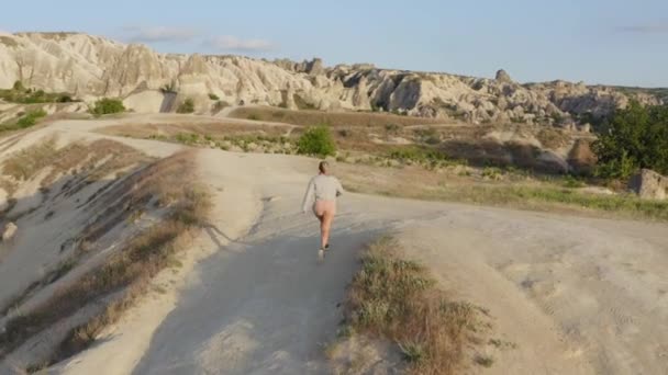 Mujer Rosa Corriendo Colina Arriba Saltando Para Usted Entre Las — Vídeo de stock