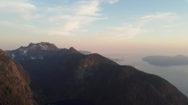 加拿大太平洋山脉蓝天和橙色天空下的落日空中无人机在雪山落基景观上鸣枪 — 图库视频影像