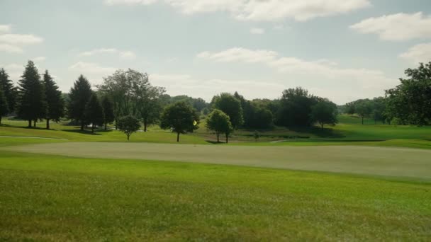 在高尔夫球场上迎风摇曳着的高尔夫球旗的轨道射击 — 图库视频影像