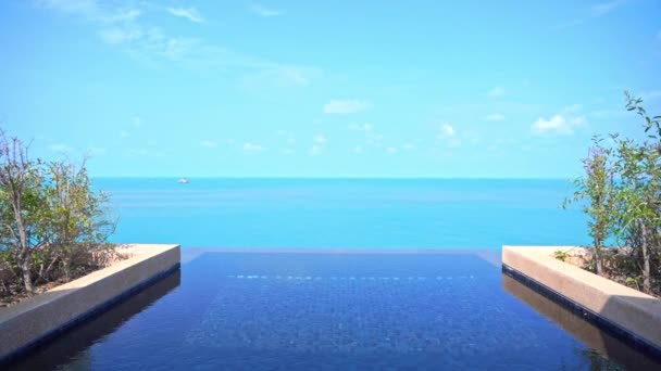 炎热的阳光灿烂的日子 海滨别墅清澈的游泳池 鸟瞰着热带海洋 — 图库视频影像
