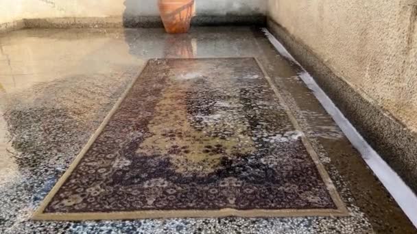 在阳台上用水洗棕色的地毯 — 图库视频影像