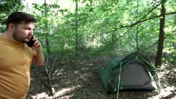 年轻人在森林里的一个野营区谈话时失去了智能手机信号 — 图库视频影像