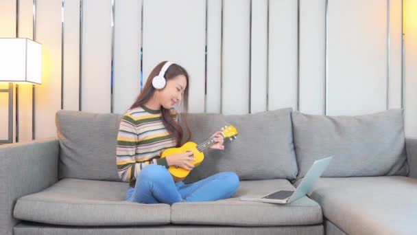 Μια Χαριτωμένη Νεαρή Γυναίκα Απολαμβάνει Κάθεται Στον Καναπέ Ενώ Παίζει — Αρχείο Βίντεο