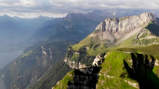 スイス アルプスの夏の朝 ニーダーボーエン チュルム山頂を空中飛行し ルツェルン湖のフィヨルドに向かって回転する山頂の崖を眺めます — ストック動画