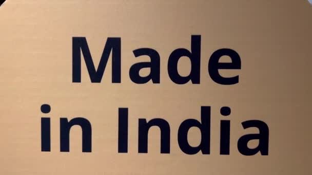 インド製のオレンジ色の板のクローズアップが書かれています このボードは インドで作られているすべての商品を表しています — ストック動画