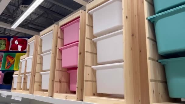 ピンク およびその他の多色の棚は 箱に保管容量を示すためにいくつかのアクセサリーを箱に入れて販売するためのディスプレイに設定されています — ストック動画