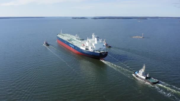 拖船护送大型原油运输船Minerva Helen通过狭窄的芬兰群岛航道 从尾心球道连接的垂直线 船只在干船坞上油漆 空中后视镜 — 图库视频影像