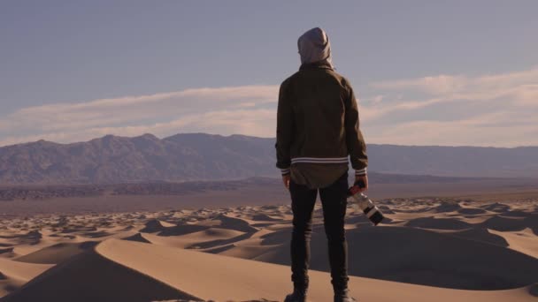 Медленное Видео Фотографом Капюшоне Стоящим Песчаных Дюнах Кричащим Огромное Расстояние — стоковое видео