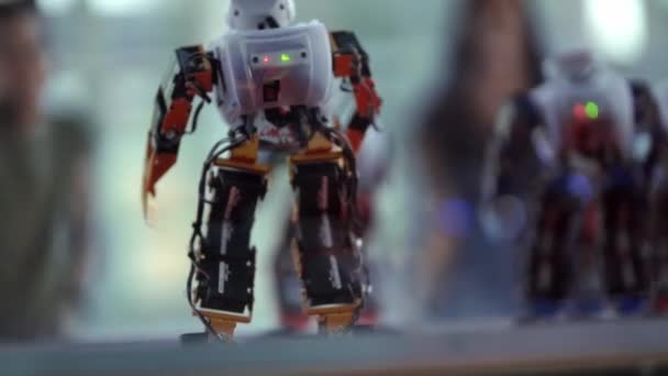 Małe Roboty Wykonują Ruchy Taneczne Ludzie Rozmytym Tle Powtarzają Ruchy — Wideo stockowe