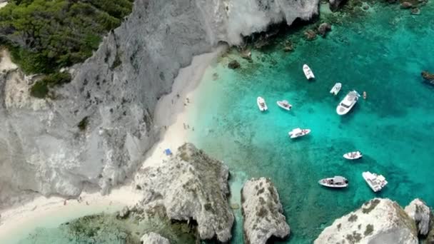 イタリアのトレミティ島のドローン映像は いくつかのボートやヨットが航海している崖と海の鮮やかな青の色を示しています — ストック動画