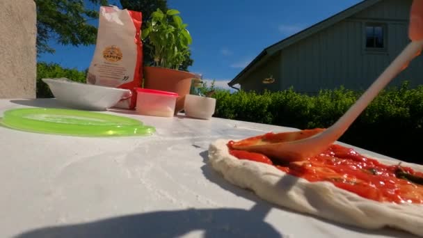 Снимок Мужчины Повара Наливающего Томатный Соус Домашнюю Пиццу Открытом Воздухе — стоковое видео