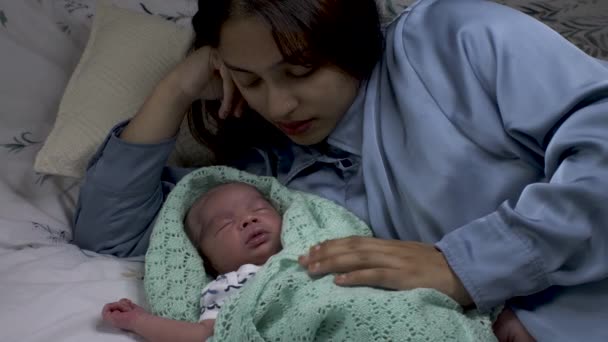 Junge Asiatische Mutter Tröstet Ihren Neugeborenen Sohn Eingewickelt Eine Gestrickte — Stockvideo