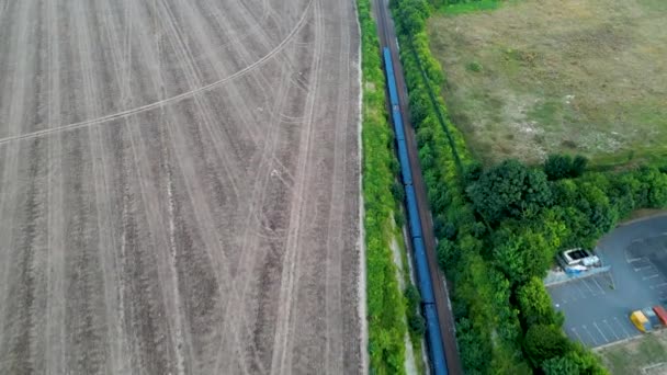 Ngiliz Kırsalından Geçen Ağaçlık Bir Demiryolunun Üzerindeki Mavi Trenin Insansız — Stok video