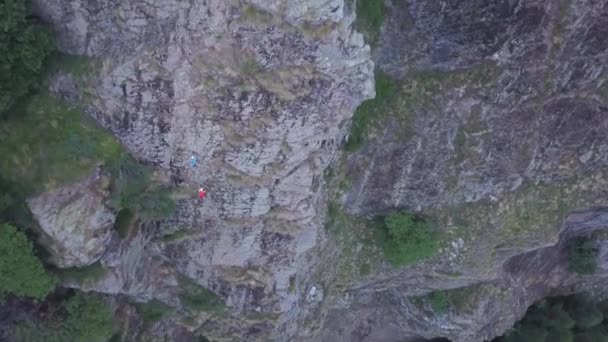 岩壁の上に2人の登山者が上昇した ドローンビューを人々の山の登山でダウン見て — ストック動画