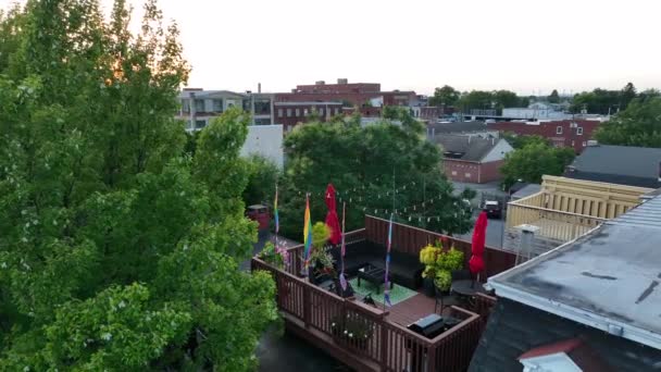 Lgbtqフレンドリーな屋外屋上レストランで虹の旗と食事 夏の空中夕日ショット — ストック動画