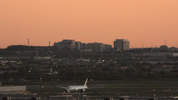 ピアソン国際空港のエプロンを横切る航空機の壮大な景色 トロント カナダなどの鮮やかな金色に照らされた夜の空 — ストック動画