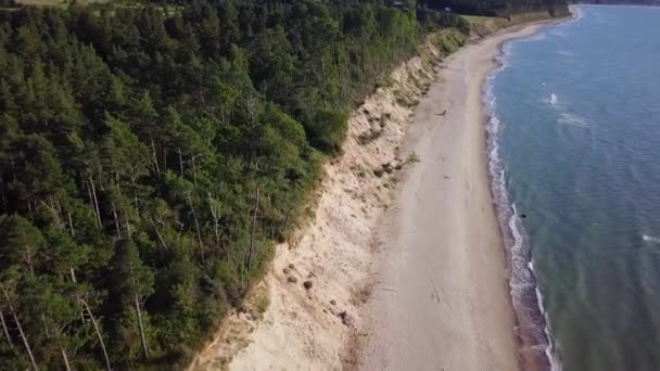 晴れた日にはジュルカルネ ラトビア のバルト海のビーチの空中俯瞰 波による白い砂の崖 海岸浸食 気候変動 前方に移動する広角ドローンショット — ストック動画