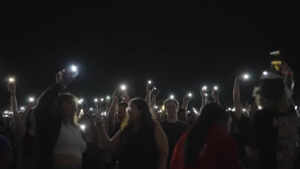 Концертний Натовп Піднятими Руками Утримуючи Телефони Ліхтарями Музичний Фестиваль Вночі — стокове відео