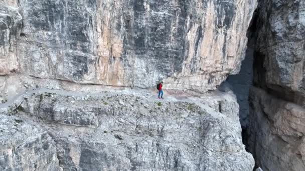 イタリアのドロミテの露出したハイキングコースに沿って歩く登山家 — ストック動画