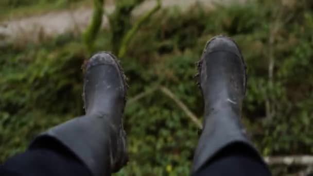 森の中でスイングしながら汚いゴムブーツの女性の足 Pov — ストック動画