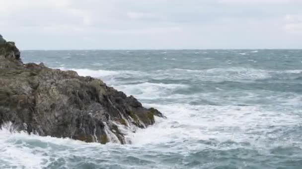 ニューキーハーバー コーンウォール イングランドのロッキークリフで広がる強い波 サイドウェイショット — ストック動画