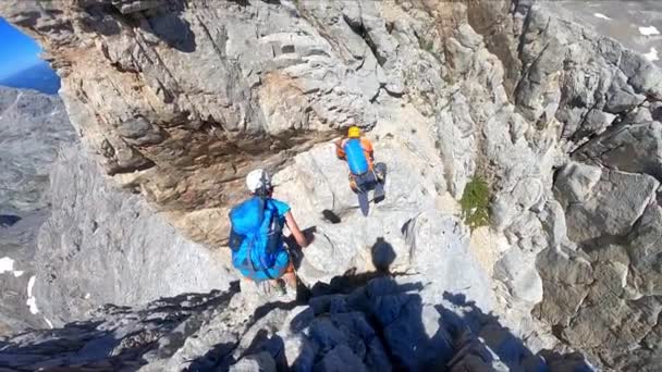 一个女孩和一个男孩登山者在非常高的岩石上攀登欧洲的山峰 头晕和动弹不得 — 图库视频影像