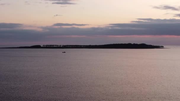 ゴリトリ島を背景に夕日の時間の間に孤独なボートのシルエット — ストック動画
