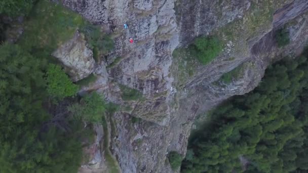 標高の高い山に登る人々の無人機からの広い空の景色を登る 冒険スポーツ愛好家と深い緑の木々の頑丈な風景 — ストック動画