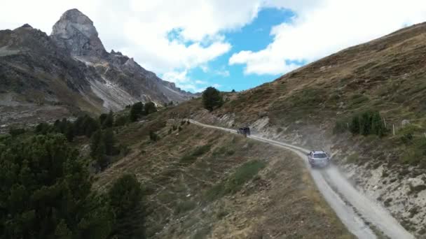 2つのオフロード車は 山道を運転している 道路はほこりだらけで急で スイスの山の中のアルプスまでずっとリードしています — ストック動画
