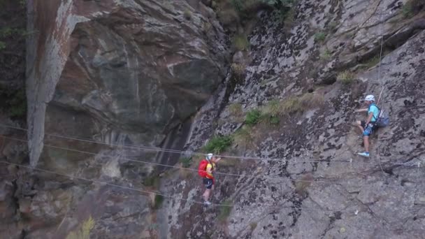 Escalador Com Pesado Pacote Vermelho Atravessando Ponte Corda Olha Para — Vídeo de Stock