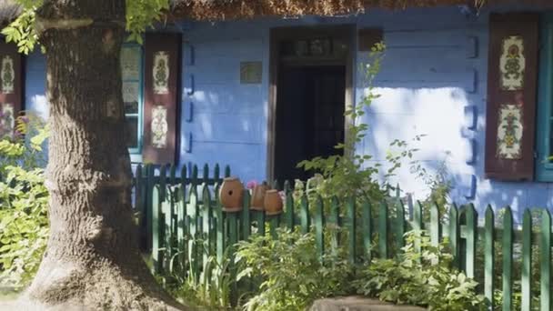 Oude Kleipotten Hangend Aan Houten Hek Voor Blauwe Hut Uit — Stockvideo