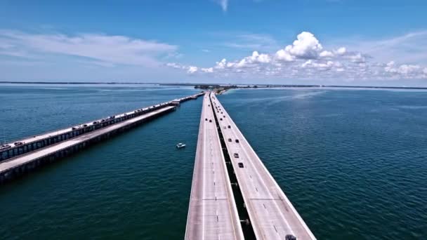 在佛罗里达州下坦帕湾阳光天桥 Sunshine Skyway Bridge 行驶的车辆可以看到渔港 空中无人驾驶飞机 — 图库视频影像