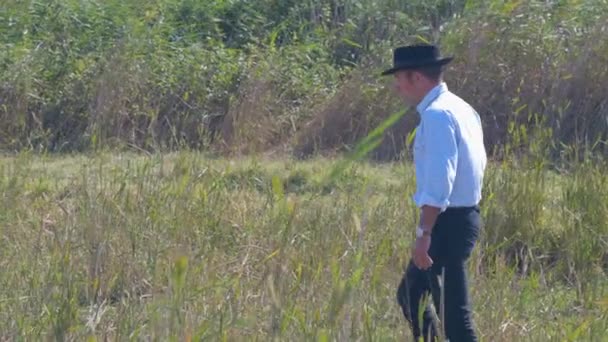 Cowboy Spaziert Hohen Gras Während Über Das Leben Nachdenkt — Stockvideo