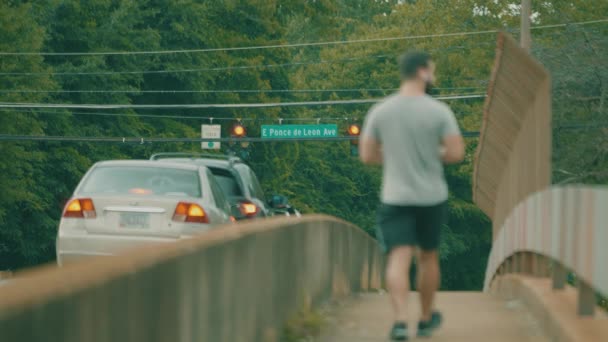 Ένας Άντρας Διασχίζει Μια Πολυάσχολη Γέφυρα Γεμάτη Κίνηση — Αρχείο Βίντεο