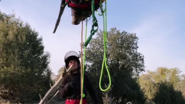 女教师训练学生用安全带吊在树上 用大量的绳索和攀爬材料 同时学习修剪高度和打结 — 图库视频影像
