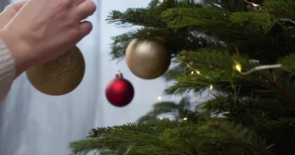 Hand Van Persoon Versieren Kerstboom Met Gouden Speelgoed Van Dichtbij — Stockvideo