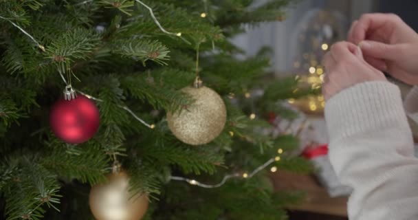 Frau Hände Mit Langen Ärmeln Schmücken Weihnachtsbaum Mit Rotem Spielzeug — Stockvideo