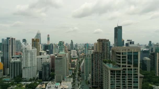 日当たりの良い日にタイのバンコクのダウンタウンにあるビルや高層ビルの空中ビューの4Kシネマティックな都市ドローン映像 — ストック動画