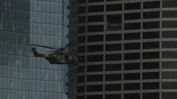 Ein Militärhubschrauber Fliegt Dicht Zwischen Den Hochhäusern Der Stadt — Stockvideo