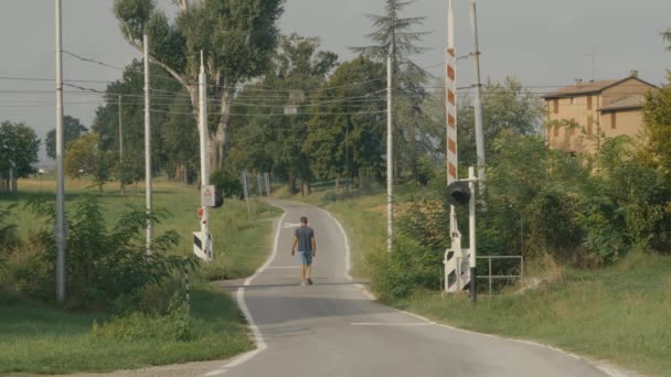 Uomo Attraversa Tracce Passaggio Livello Piedi Vicolo Campagna Nella Pianura — Video Stock