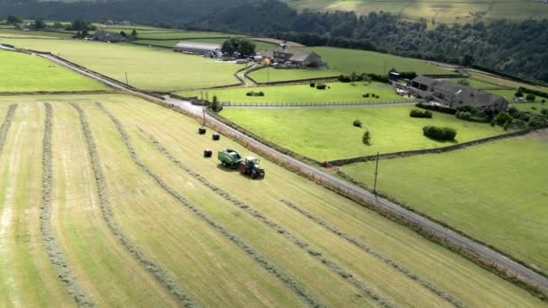 ヨークシャーの田園風景の空中風景の上で干し草を収穫グリーントラクター 自然の風景 農業現場 — ストック動画