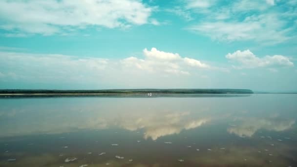 在白天飞越马加迪湖平静的水面飞向火烈鸟觅食的火烈鸟 — 图库视频影像