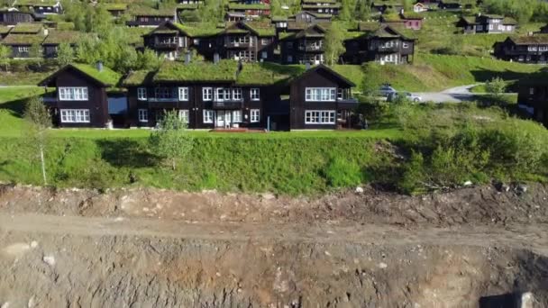 Flying Grass Roof Mountain Apartment Building Revealing Large Field Cottages — Stock Video