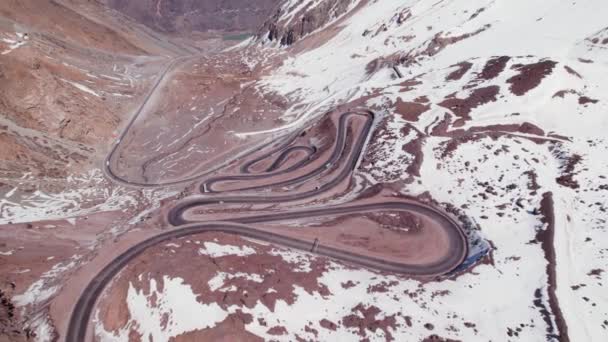 在智利安第斯山脉雪山上危险的发夹路上行驶的车辆 空中下降 — 图库视频影像