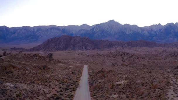 ホイットニー山を望む岩の多い砂漠の風景を通って映画道路 ドローン — ストック動画