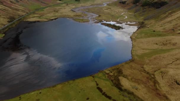 小さな湖の上に空中撮影し Glencoeハイランドバレーに位置する美しい山々を明らかにします スコットランド — ストック動画
