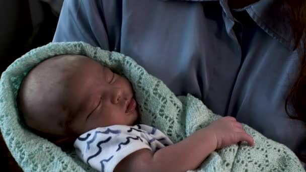 毛布に包まれた母親の腕の中に抱かれた美しい新生児の終わり彼は静かに眠りながら目を閉じて — ストック動画
